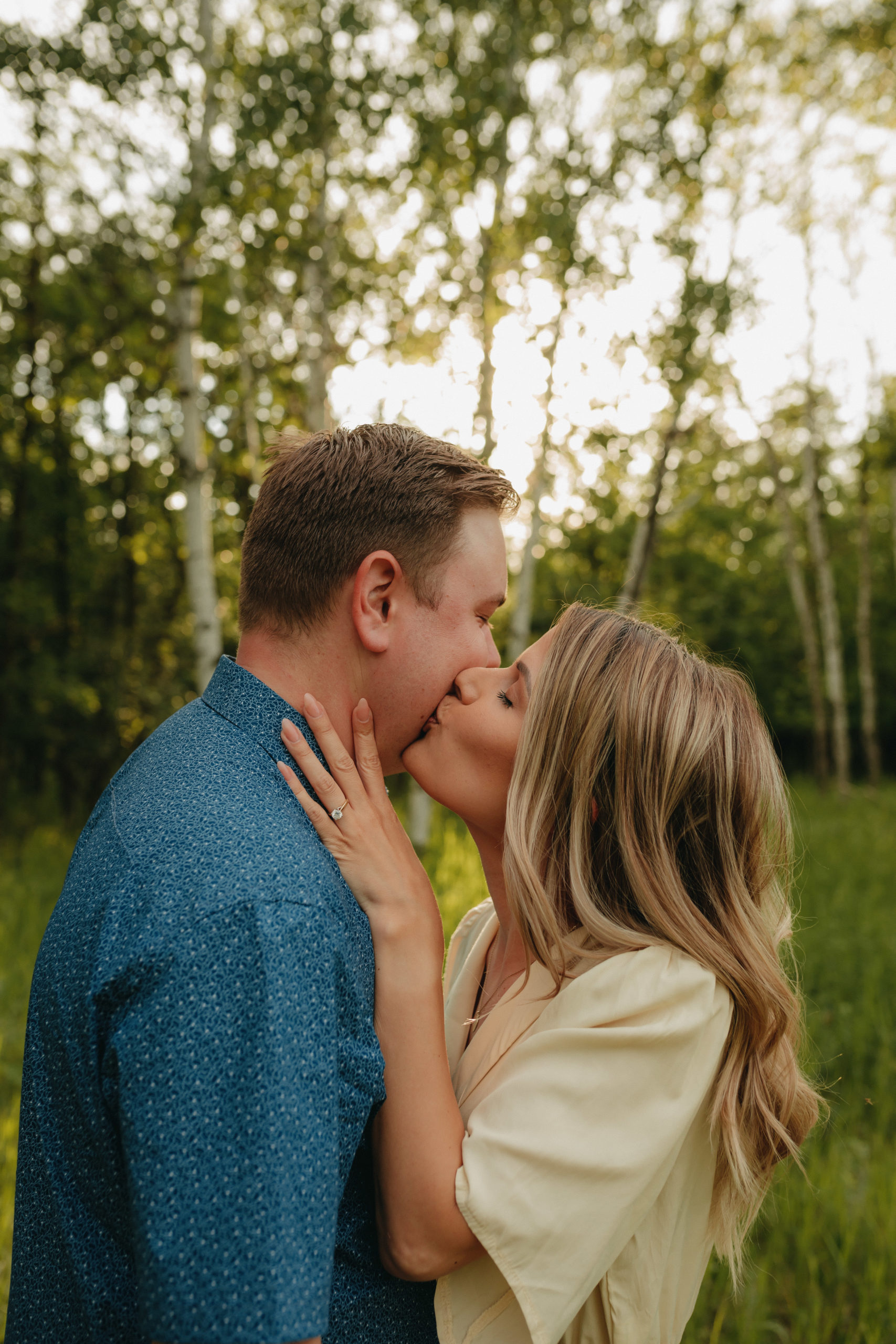 Woman kissing man's cheek in the forest