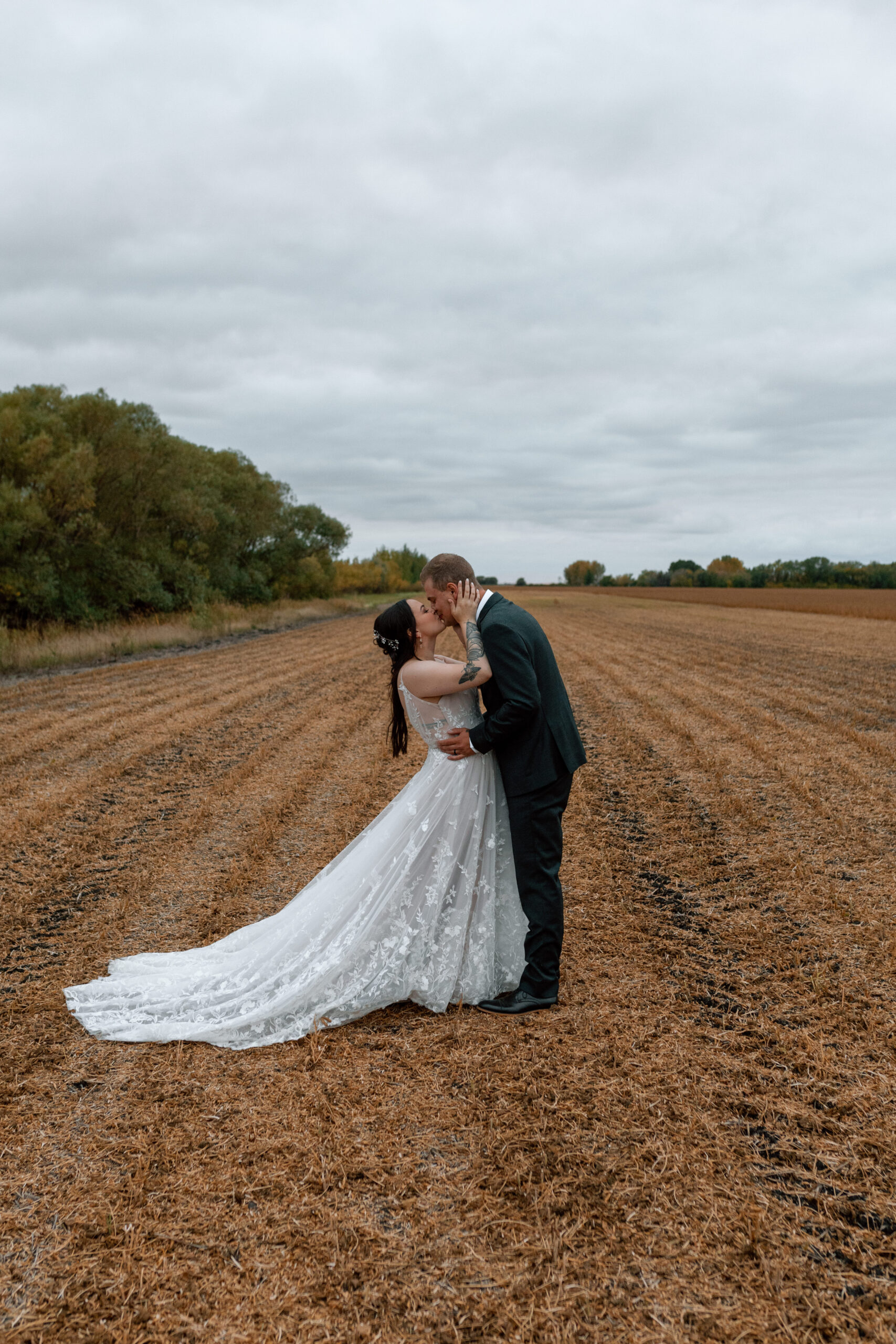 bride and groom kissing in wheat field