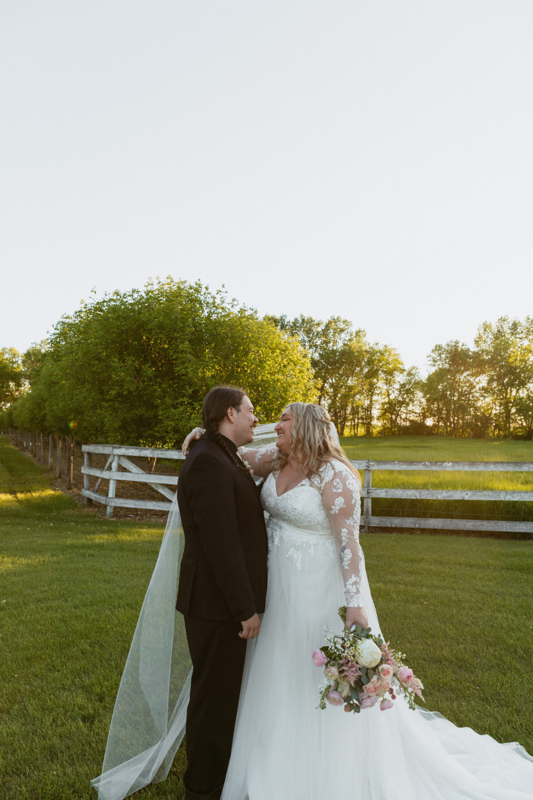 bride and groom at sunset holding hands