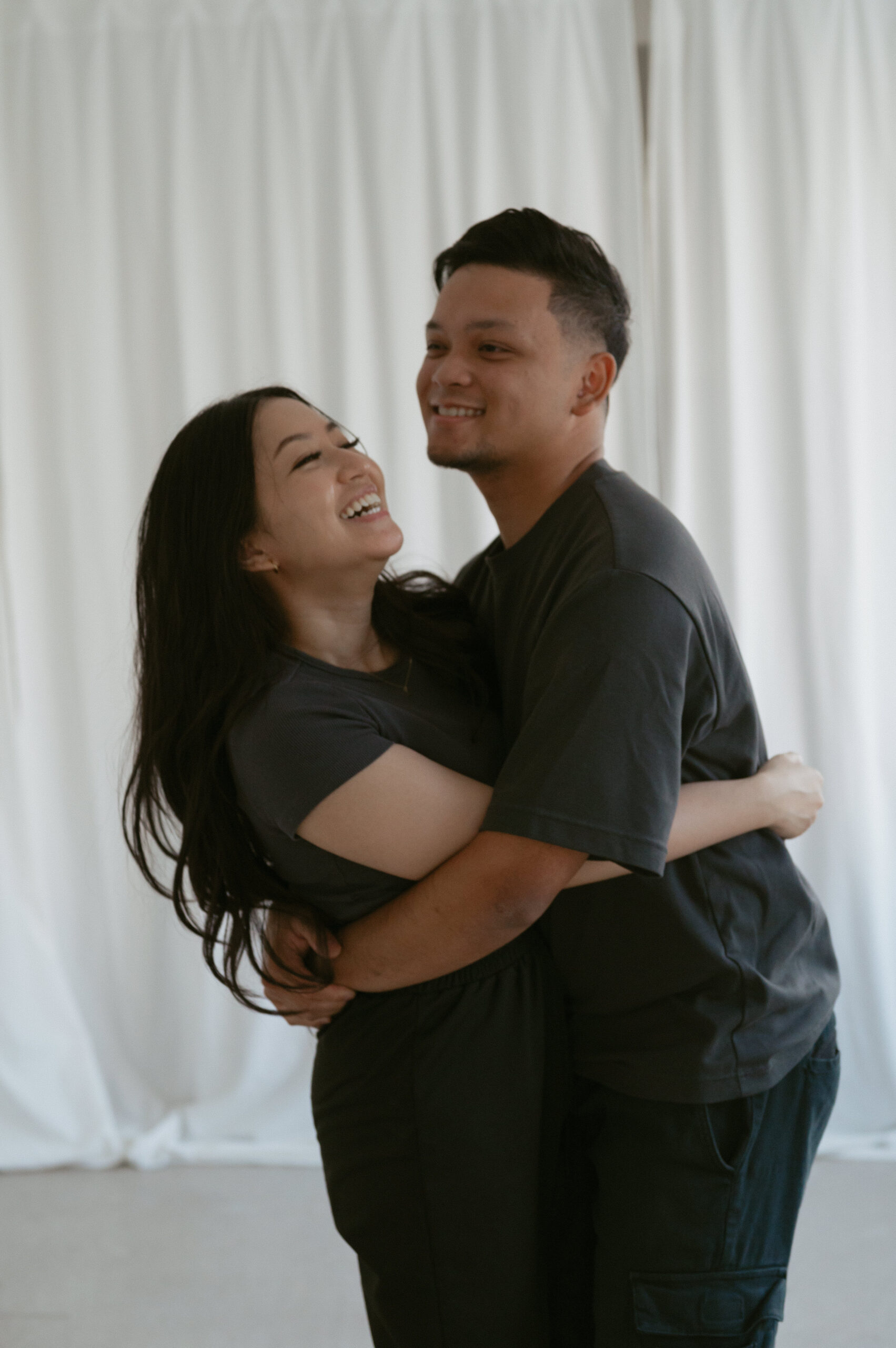 couple hugging and laughing in studio