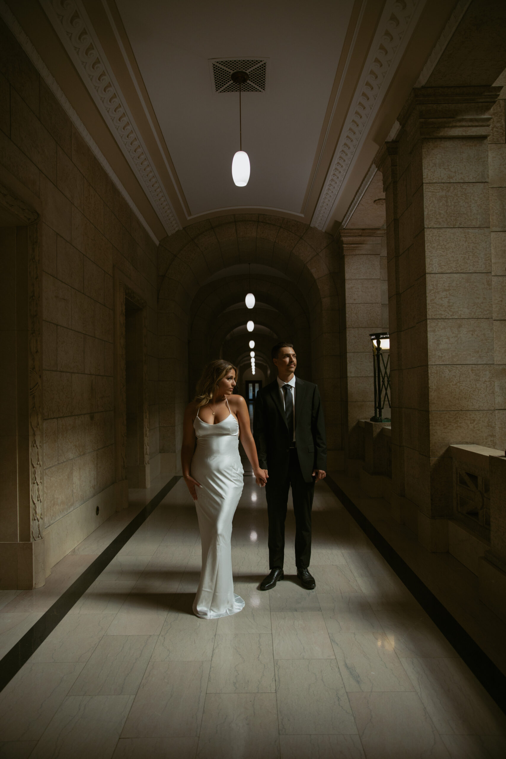 Couple holding hands in a dimly lit hallway