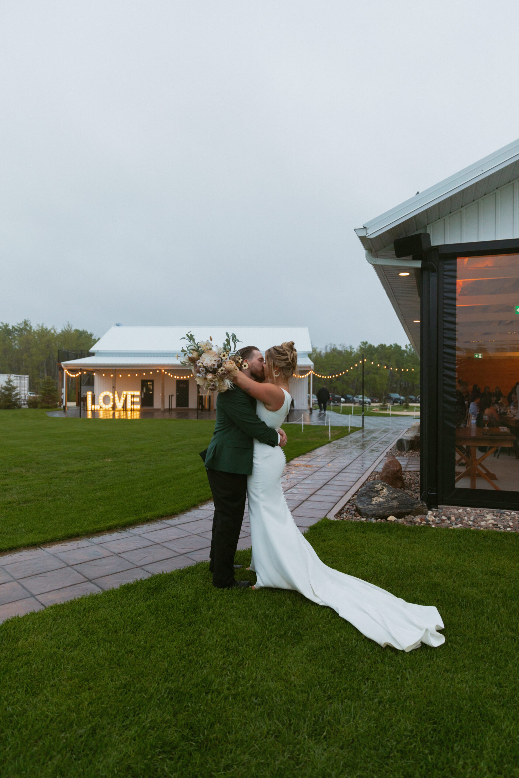 bride & groom kissing in the rain