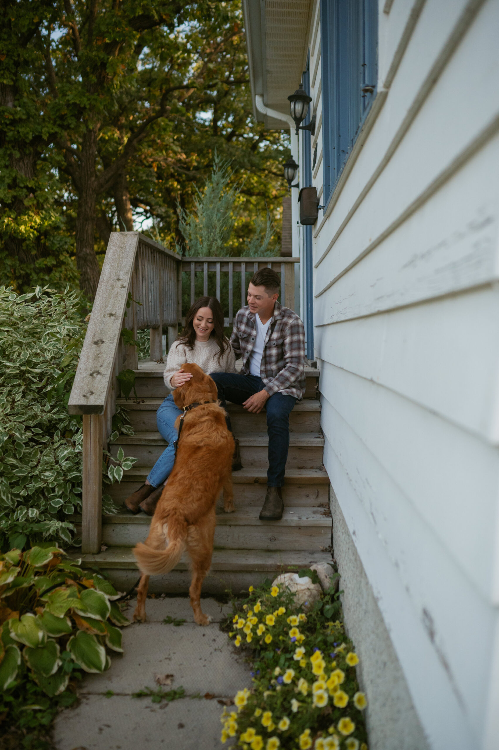 Couple sitting on their front step with their dog