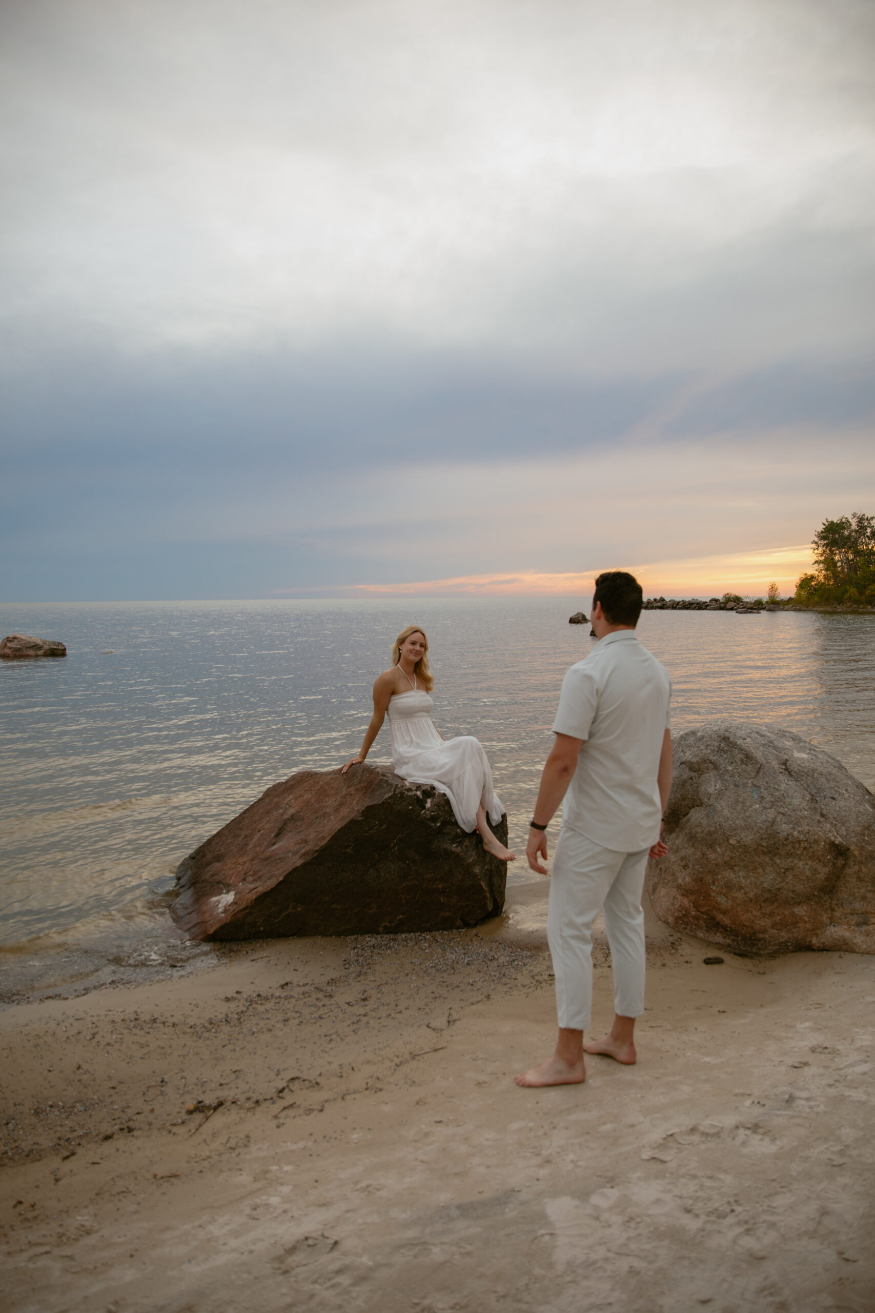 Couple sitting on beach at sunset