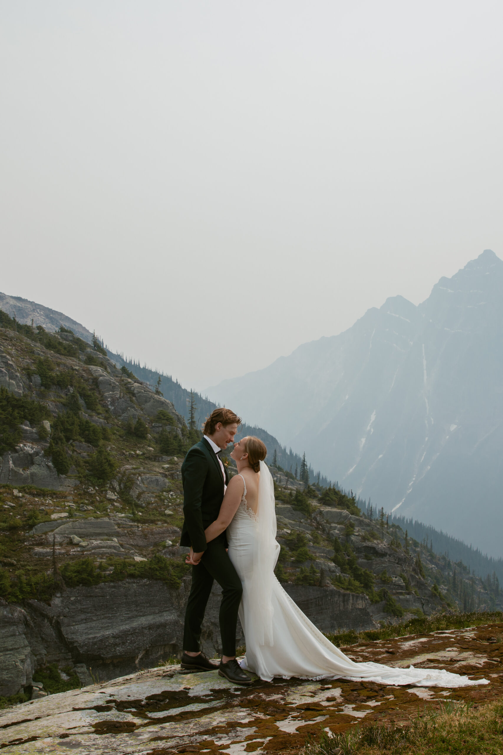 Bride and Groom laughing on mountain summit