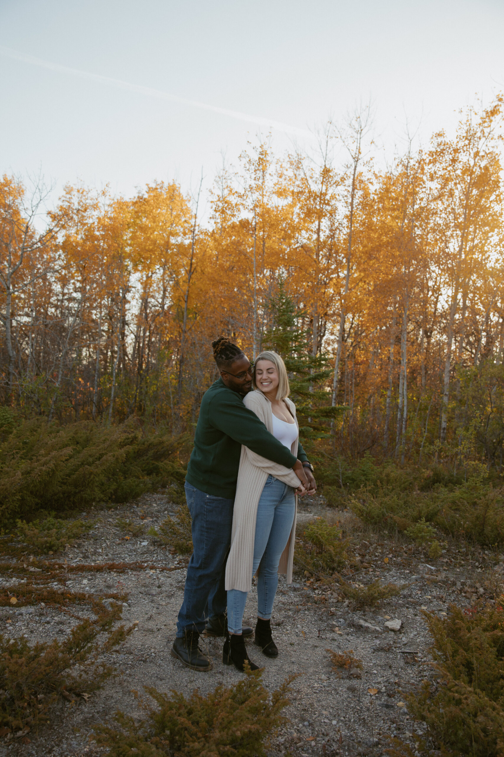 Mixed race couple cuddling in an autumn leaved forest