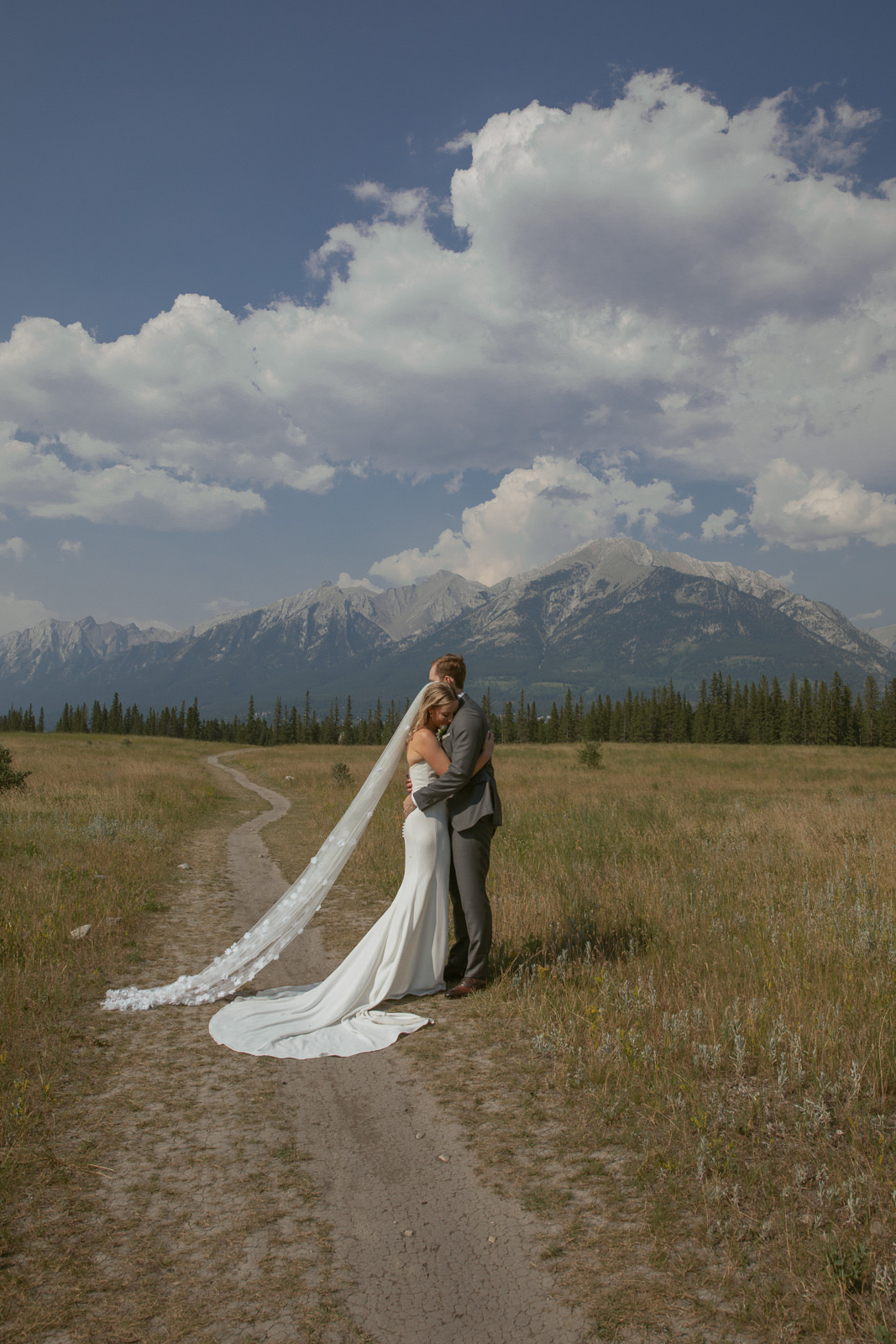 Bride and groom embracing in a mountain field