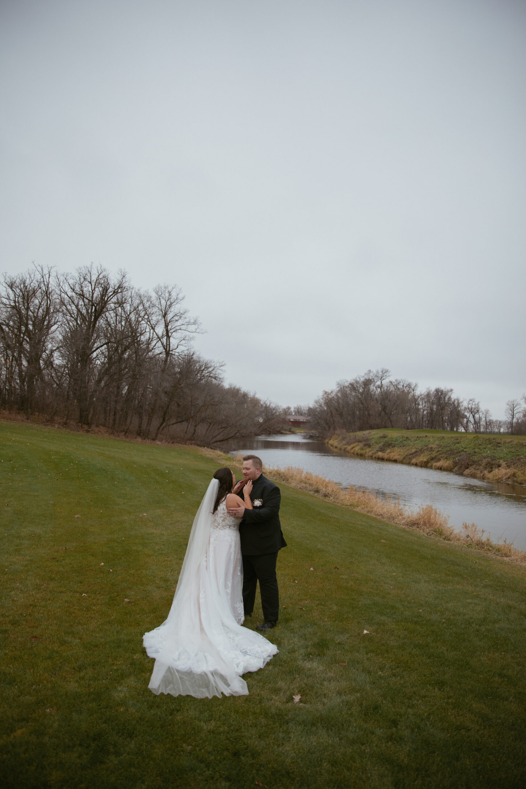 Bride & Groom kissing by the river