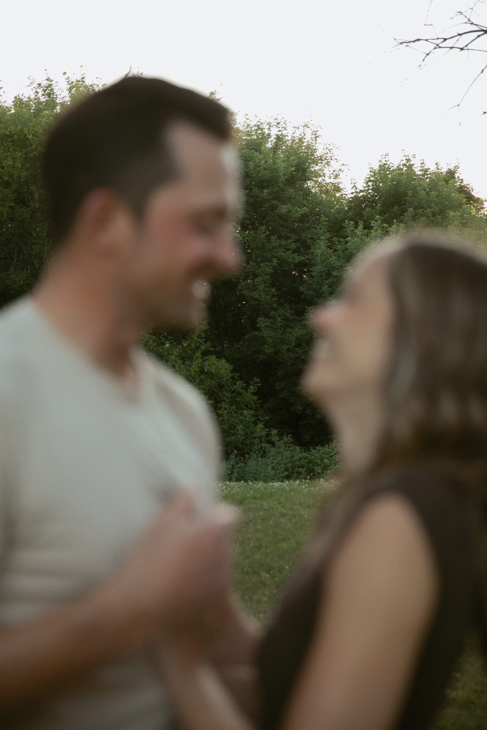 Couple laughing in forest at sunset