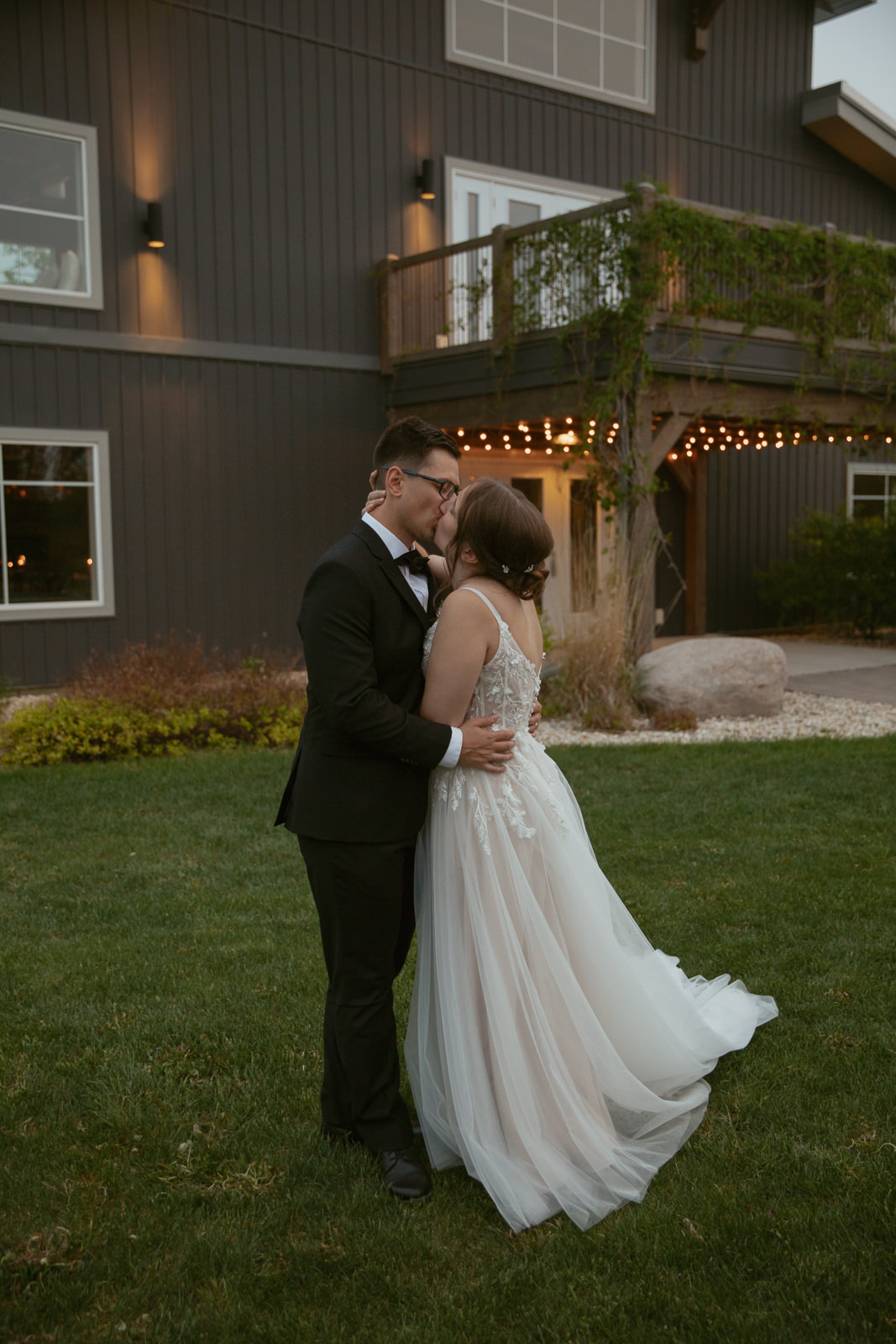 couple kissing in front of barn venue